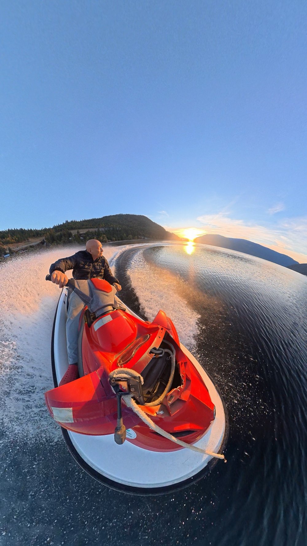 Jet ski at sunset on Shuswap Lake, spray flying behind