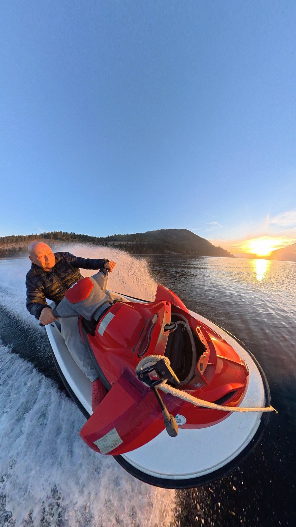 Jet ski at sunset, mountains across the lake