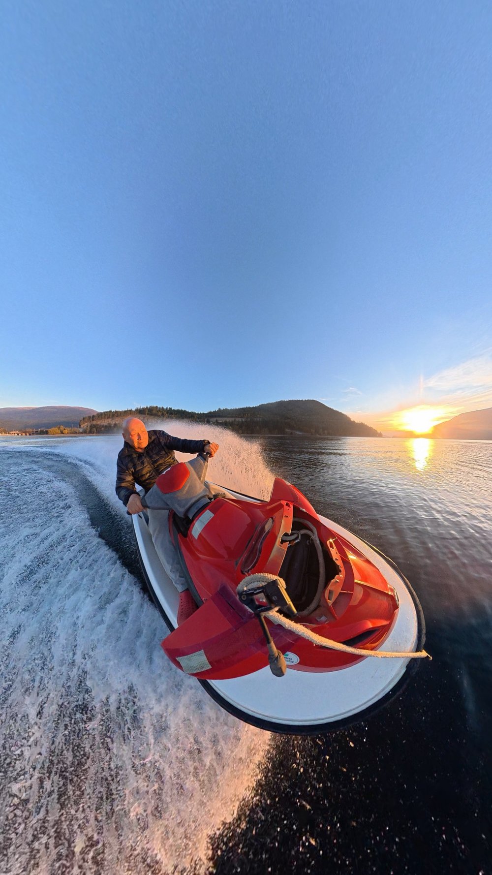 Jet ski crossing Shuswap Lake with spray trailing behind