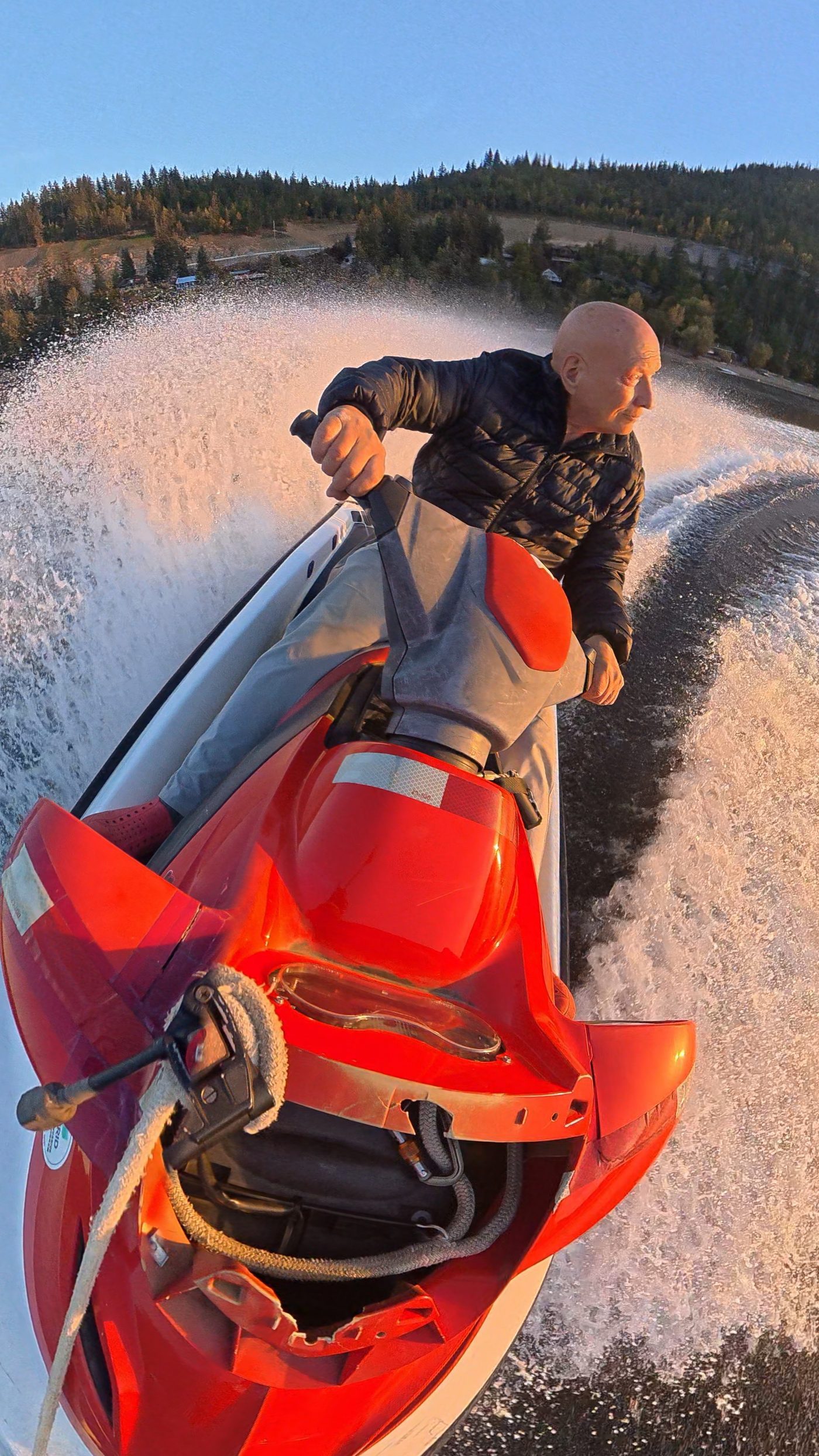 Action-camera view from a jet ski on Shuswap Lake at sunset, spray in the air
