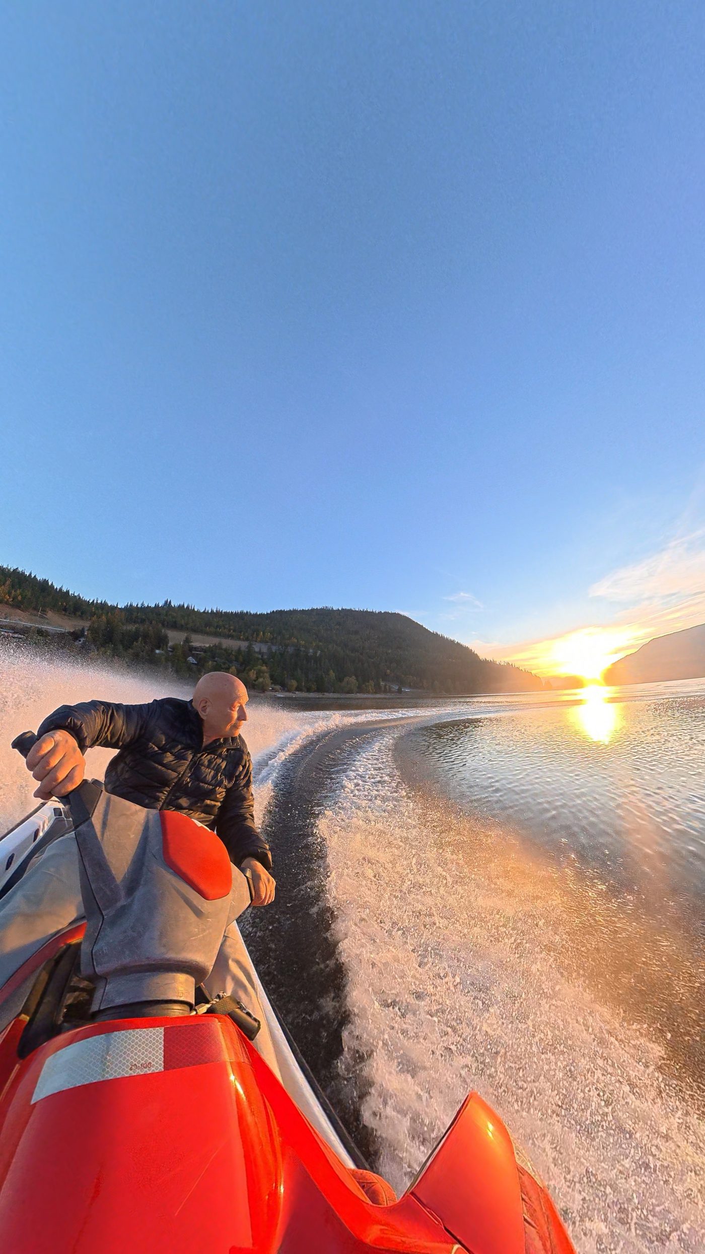 Jet ski action shot on Shuswap Lake with spray catching the evening sun