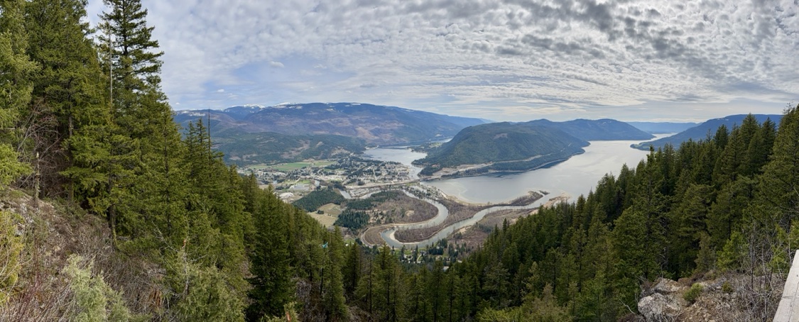 Panoramic summer view from the mountains over the Sicamous valley, with the town, Shuswap Lake and the winding river below